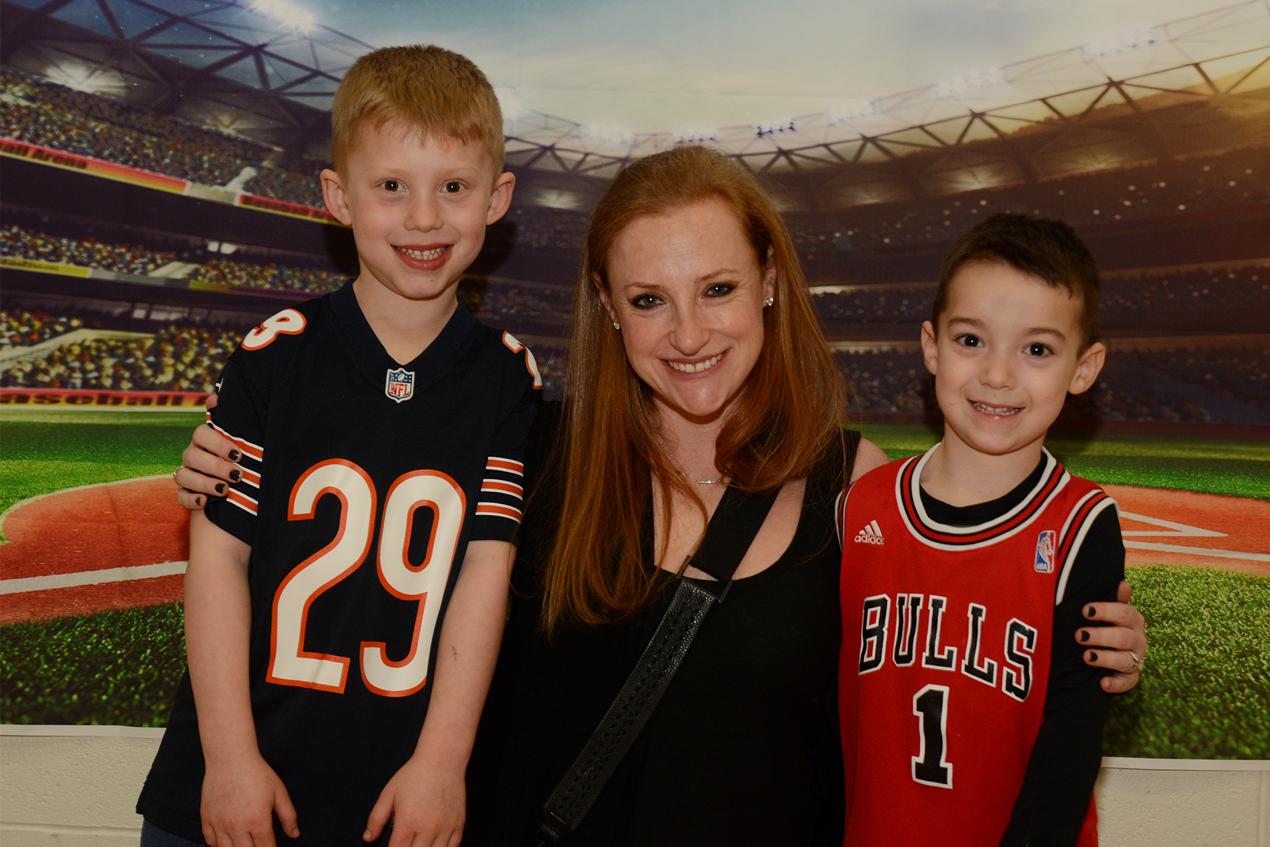 A woman and 2 kids wearing sports jersey's