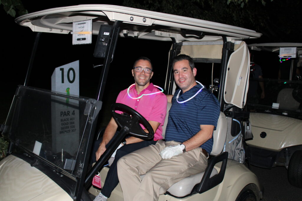 2 men in a golf cart at moonlight golf